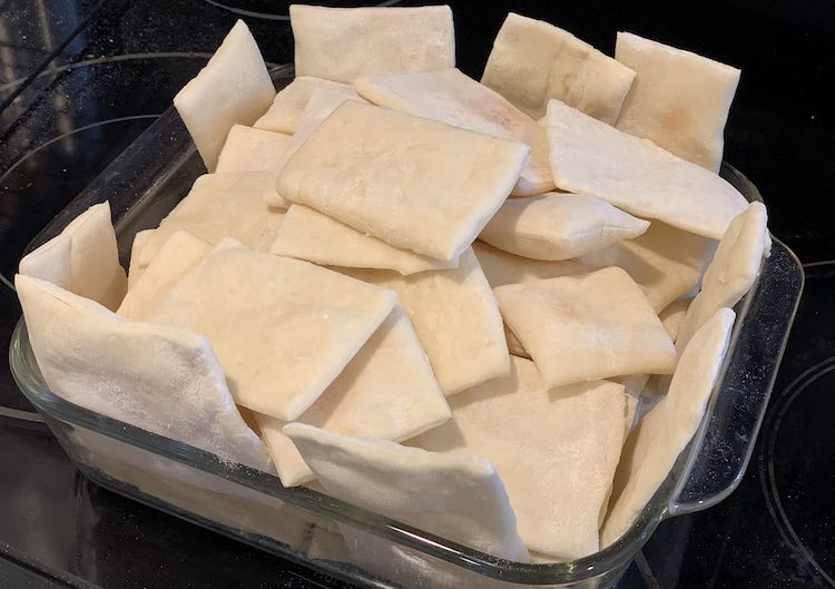 Square casserole dish filled with baked pizza crust.