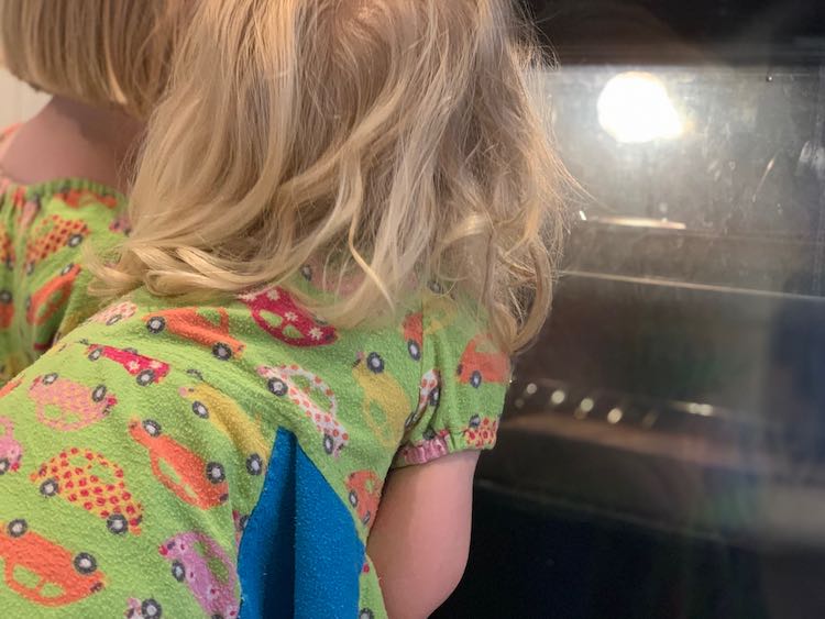 Ada and Zoey staring into the lit up oven watching the crayons slowly melt.