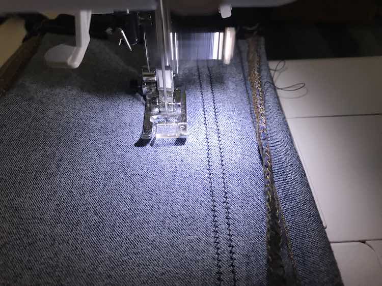 Sewing along the pant leg making sure to keep the stitches evenly apart from the previous row of stitches.