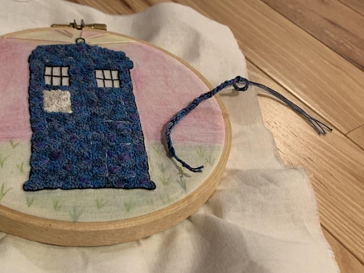 Crocheted string matching the TARDIS' main colors tied off on either end.