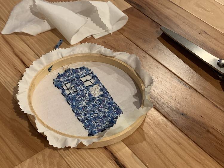 Flipped over embroidery hoop showing the TARDIS butt and the trimmed fabric sticking out the sides. 