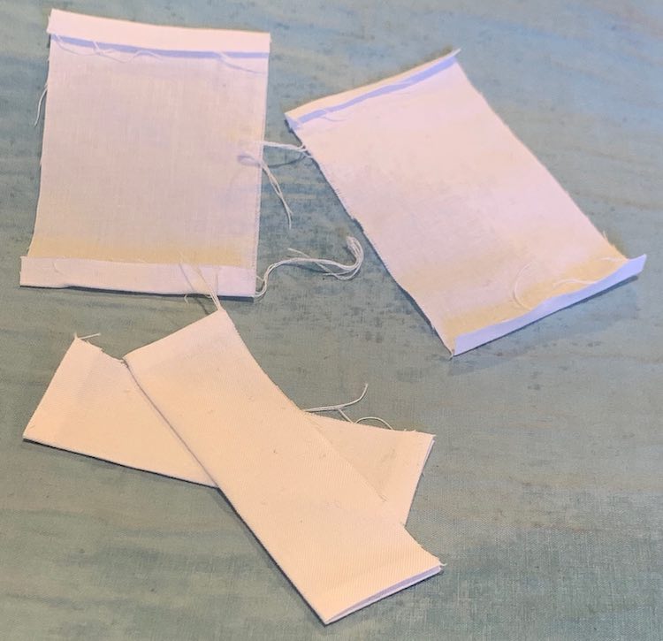 The four placket sides; two with their ends pressed in and the other two ironed completely (ends pressed and folded lengthwise).