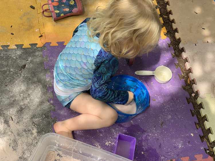 Zoey playing with oobleck in her swimming suit.