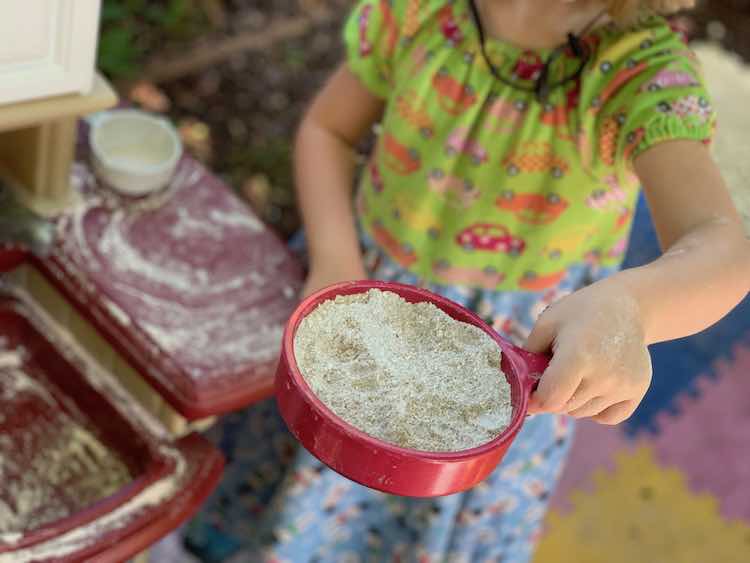 Frying pan of oobleck sand and real sand mixed together. Rest of the image blurred. 