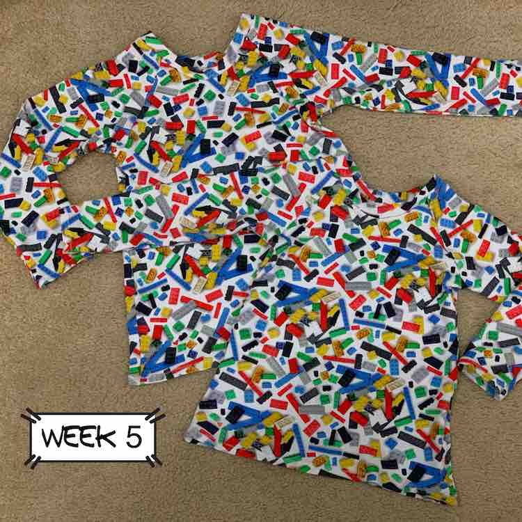 Image of two long sleeved knit shirts laid over a rug. The fabric is white with multi-colored bricks consisting of green, yellow, black, grey, and blue.
