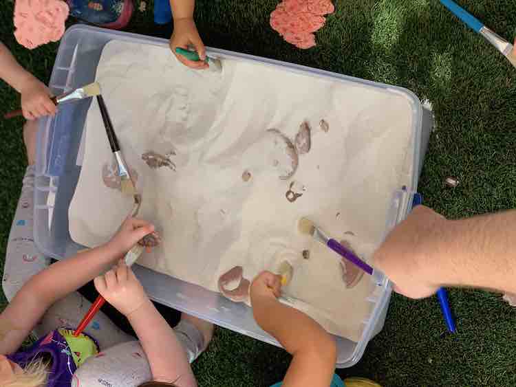 Dad and kids excavating fossils from the bin.