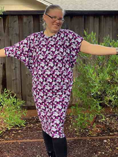 Shot of the knee length skirt worn with black leggings. Looking at the picture the left arm has an elbow length sleeve while the other arm has a drapey short sleeve creating two different looks with minimal effort.