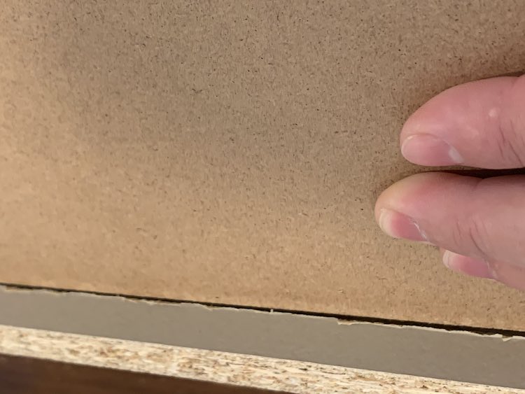 Closeup of the center of the upside down drawer. You can see my fingers (to the right) holding down the drawer base. Since the base is shoved into place you can see the groove where the drawer base used to sit inside. 