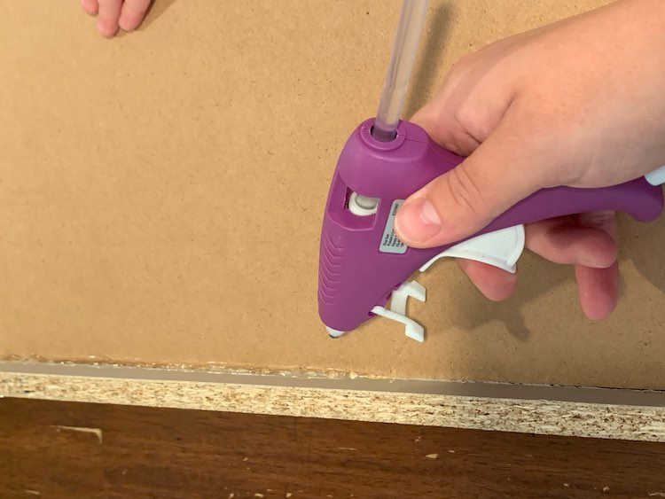 With Zoey’s little hand in the top holding down the drawer base you can see the gluing happening. The bottom of the picture shows the glued section of the drawer and my glue gun posed above it. 