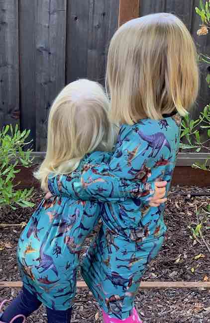 Hugging while wearing the dinosaur dresses.