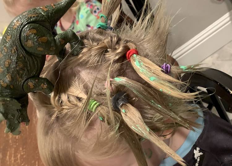 Side view of the hair shows the dinosaur who appears to be roaring. You have a view of the green flecked hair pointed away from Ada's head and the individual 'grass' at the back.