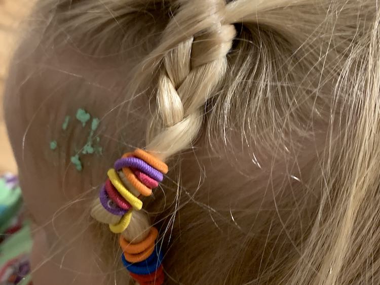 I swept some of Zoey's hair back into a small French braid then continued it down into a braid. I ended it with all the ponytail ties so there's a rainbow of color at the end. Behind the braid is a section of green flakes in her baby hairs.
