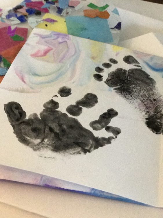 Card opened and showing the front inside. Zoey's hand print is near the bottom of the card and her footprint is near the top.