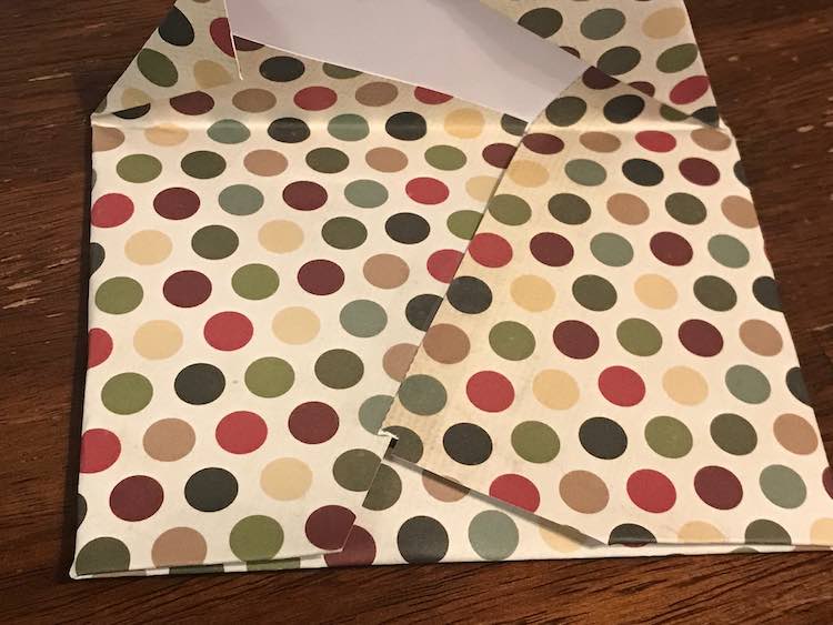 A polka dotted enveloped encircling one of the cards. The image shows the back of the envelop so you can see where the folded in sides overlap each other and the folded up bottom.