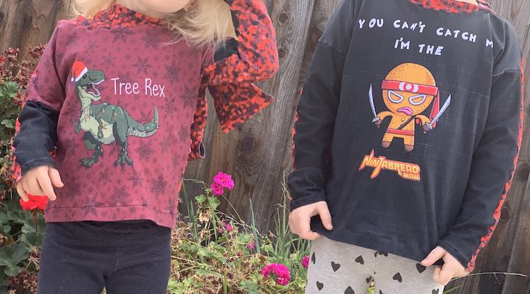 Front view of both Ada and Zoey's shirts. Zoey's is a Tree Rex while Ada's is a NinjaBread Man.