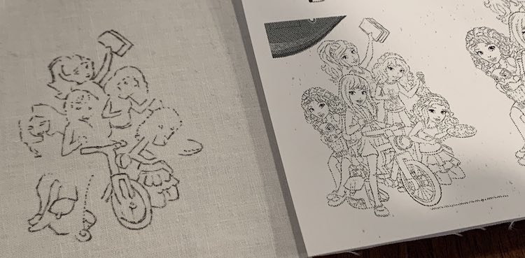 Closeup of two images showing the LEGO® Friends. The image on the right is part of the printed out coloring page. The image to the left shows a partial drawing using black ink on white woven fabric. 