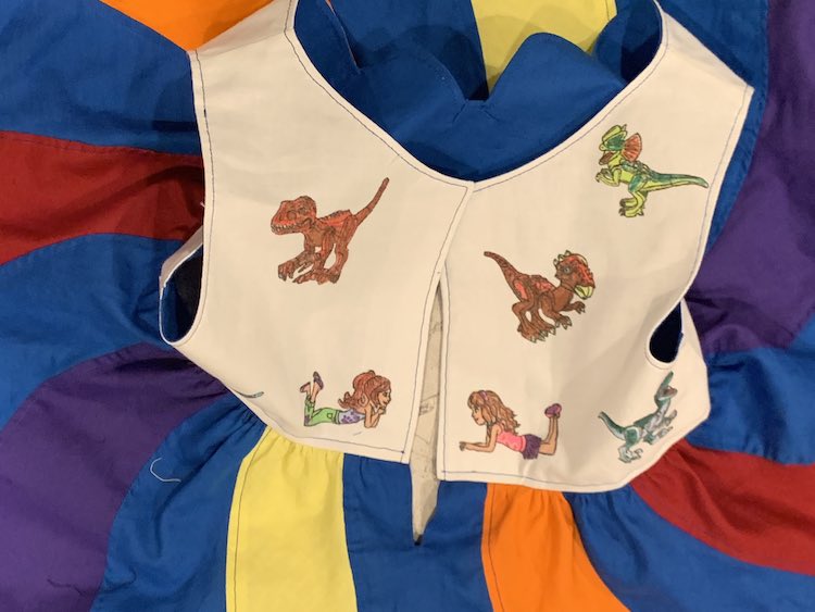 The back of the bodice is, mostly, visible showing the two laying down LEGO® Friends and four of the five dinosaurs. The skirt swirls are radiating out from the bodice.