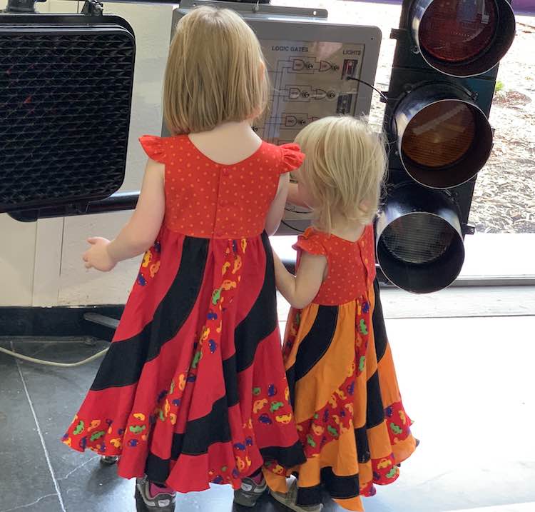 Ada and Zoey playing with the traffic lights in a children's discovery museum.