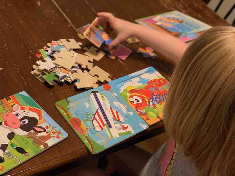 Back view of Ada’s head while she sits at the table doing the puzzles. 