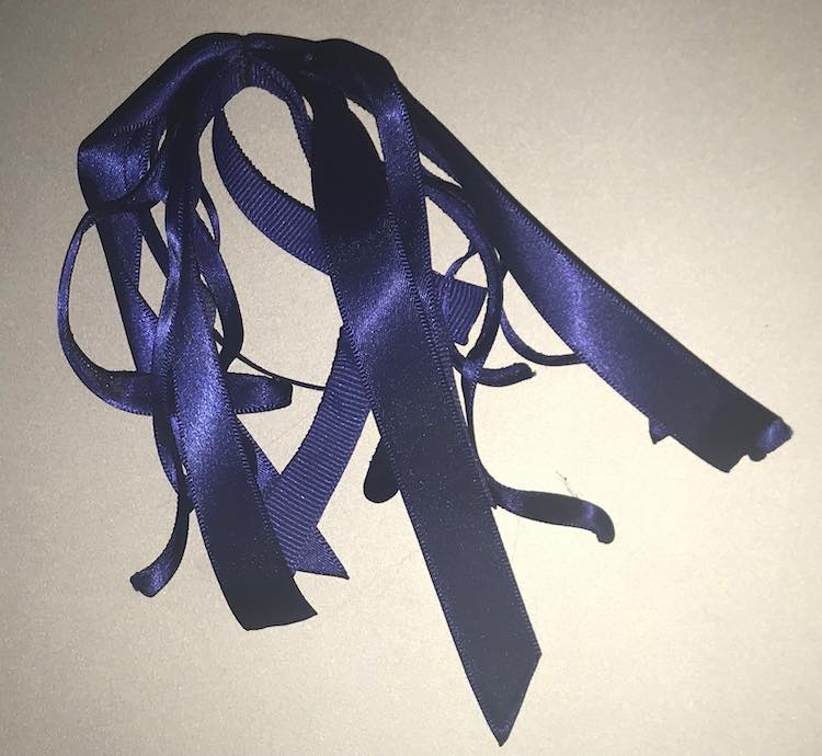 A stack of the two differently sized ribbons after they were sewn through. At the top of the image it shows all the ribbons sewn through. 