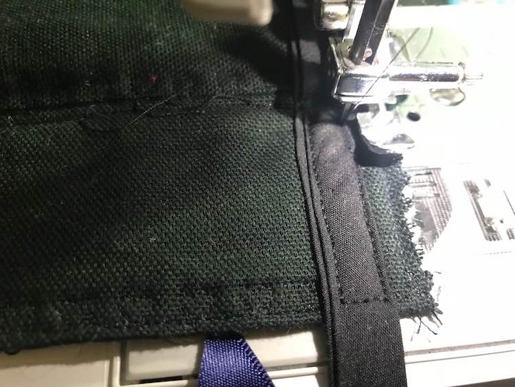 A closeup of the underside of the front flap is shown under the sewing machine foot. The foot used was a zipper foot though I can't remember the purpose of using that foot.