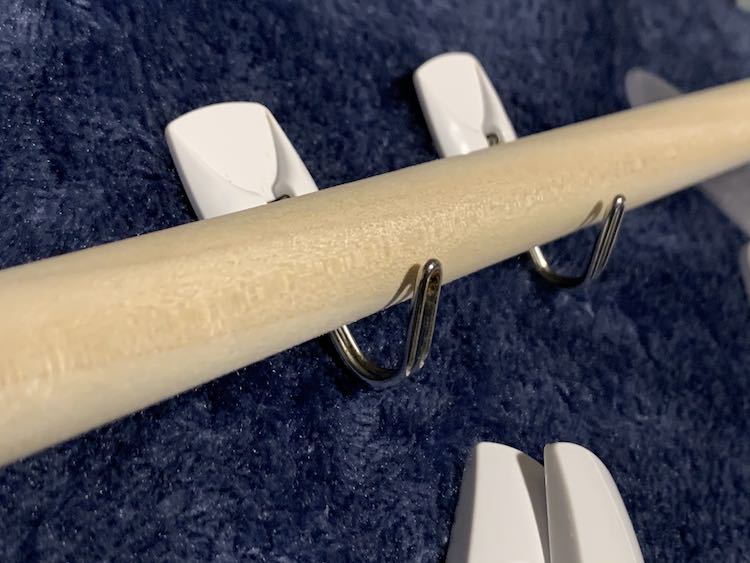 Dowel laid out in two small command hooks.