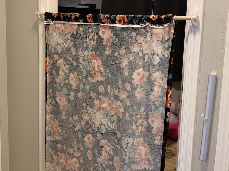 Closeup of the back of the curtain showing the folded over edge and seam. This time it's sitting in place in the bedroom doorway so the kids inside can see the flowers on the curtains. 