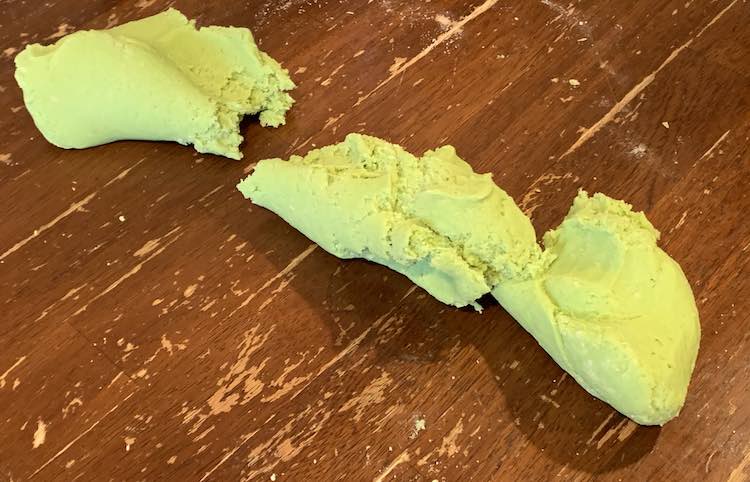 The playdough is spread out in, basically, a line from the upper left of the photo to the lower right. As it was pulled it broke in place about a third down from the top. About a third from the bottom you can see another point that was getting closer to splitting. 