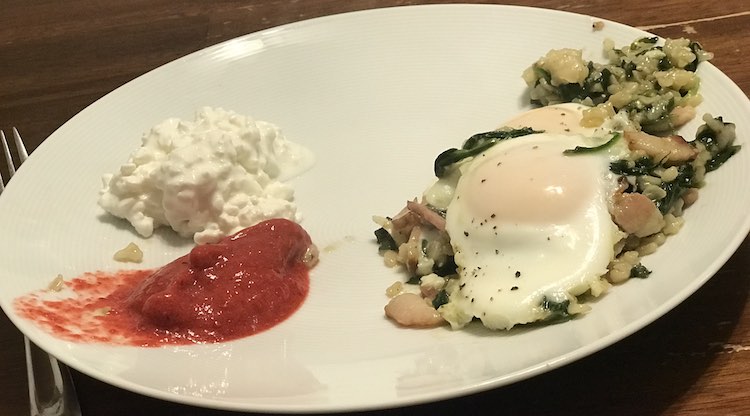 Plate showing a barely based food topped with a fried egg on the right and two piles (cottage cheese and the blended applesauce) on the left.