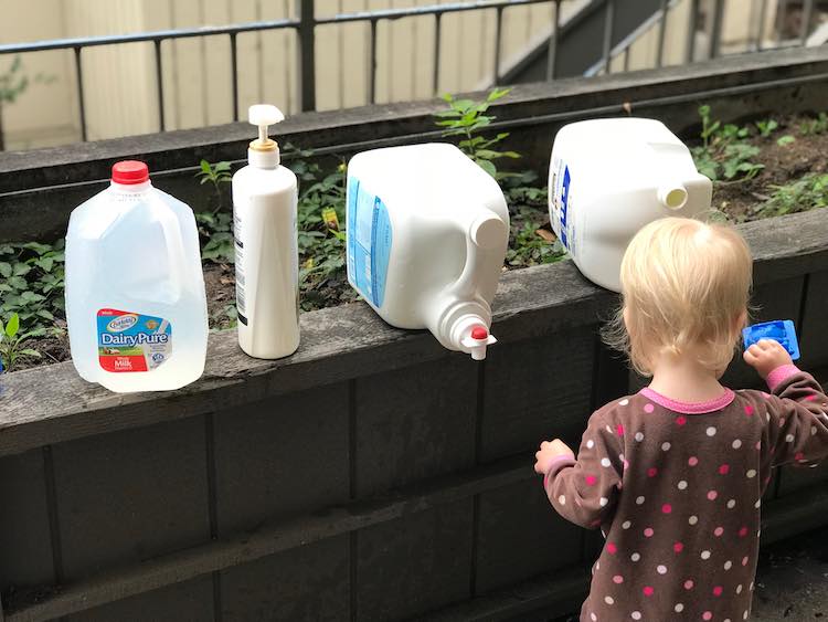 Zoey standing in front of the row of filled bottles playing happily.