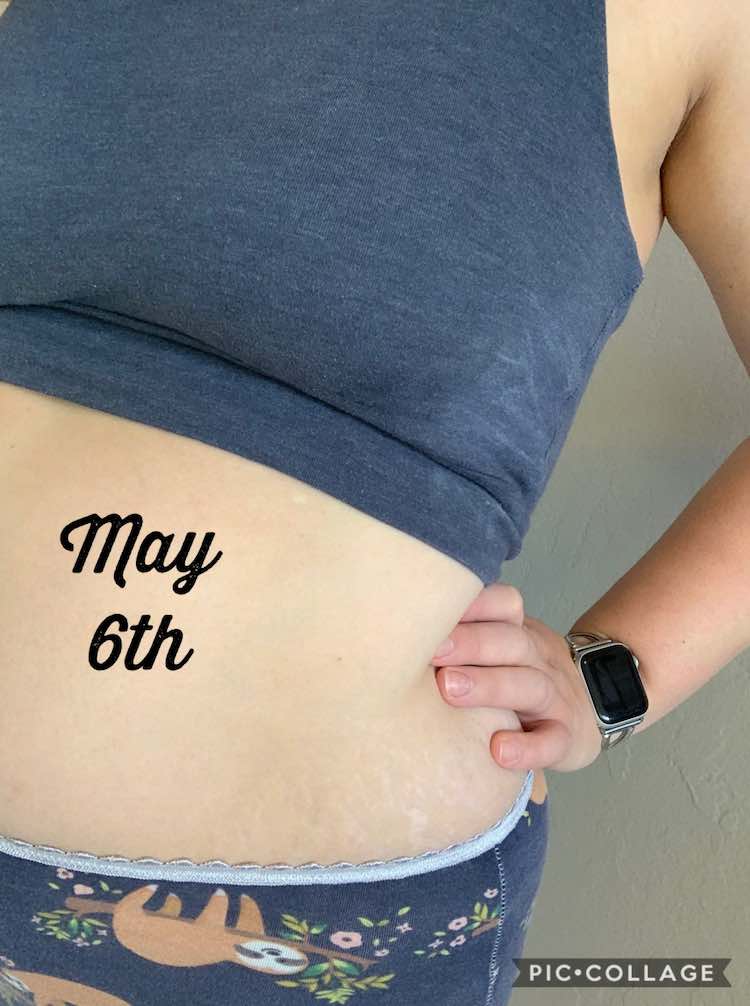 Closeup of my side and an arm. My hand is on my hip and I'm wearing a blue knit bra and navy underwear with sloths. On my stomach is black font saying 'May 6th'.
