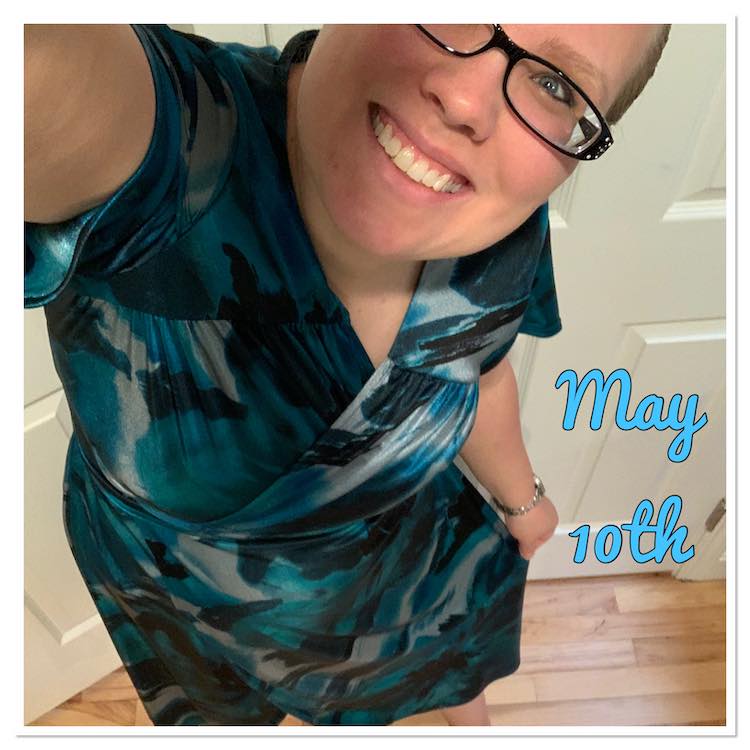 Selfie view showing one eye and the bottom of my face, tilted to fit, along with my dress. It's a wrap dress with slink ITY in blues, grey, and black. To the right of me are the words, in blue, saying 'May 10th'.