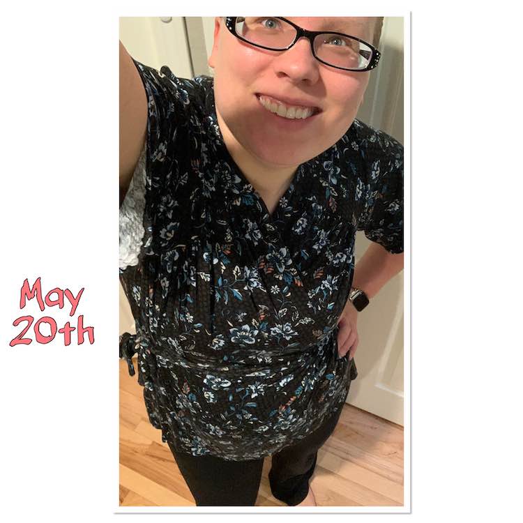 Selfie view showing both my eyes this time! The top is a short petal sleeved wrap shirt tied at the waist. The fabric is black with teal and white flowers and a hint of pink. To the left, in pink, it reads 'May 20th'. 