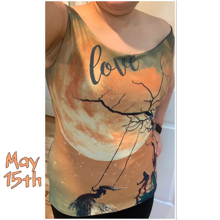 A just off the shoulder top highlighting a cityscape/landscape custom printed panel. The top, right under the neckline, says 'love' and features a large moon in the background with a silhouette of a man pushing a woman on a swing hung from a tree in the foreground.