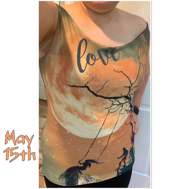 A just off the shoulder top highlighting a cityscape/landscape custom printed panel. The top, right under the neckline, says 'love' and features a large moon in the background with a silhouette of a man pushing a woman on a swing hung from a tree in the foreground.