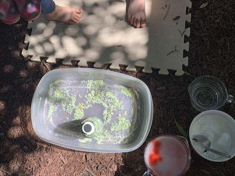 Image is taken from above looking down at the volcano and ingredients. You can see one of each of their feet above. 