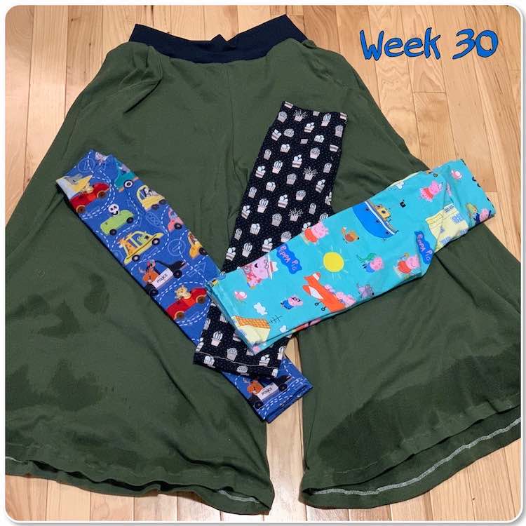 Image shows an adult sized green and wide-legged pant for me with three pairs of leggings folded and laid out at angles from one another. The leggings are all the same height though the leftmost one is skinnier that the others. Overlaid at the top it says "week 30".