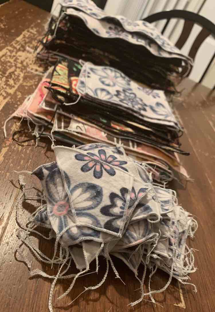 Photo showing the napkin piles from the side. Closest in the image are the face cloths, next is the small pike of square napkins, and finally is the tall pile of the larger rectangular napkins.