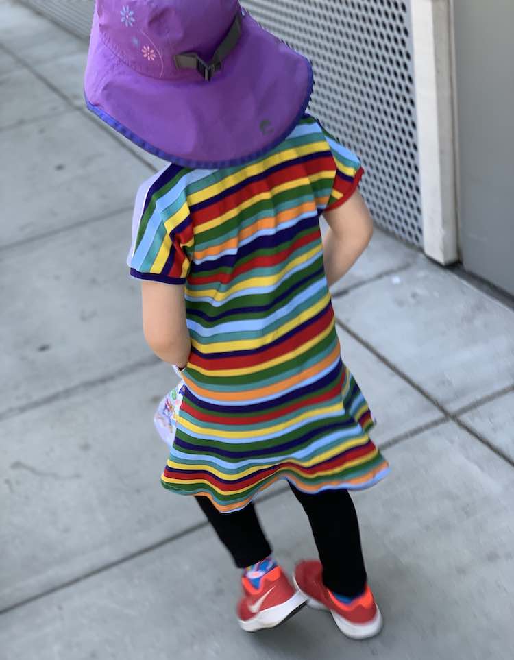 View of Ada's back as she walks away showing an unbroken repeating colored stripes going across her back. 