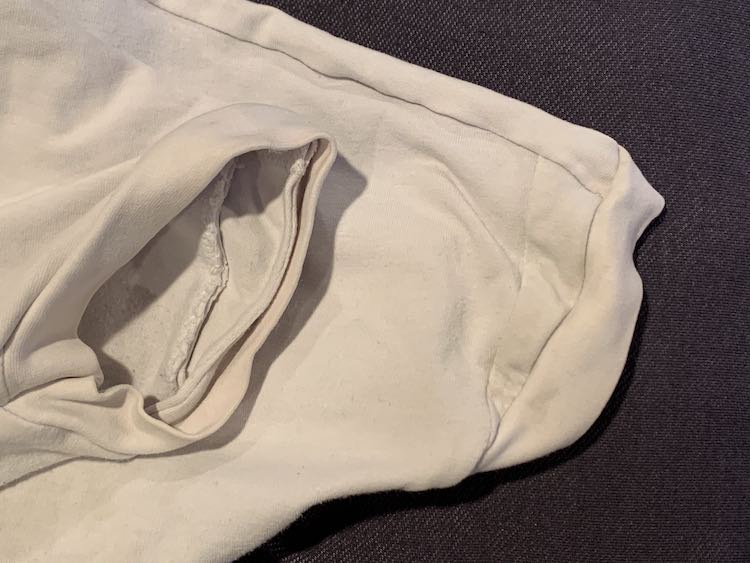 Image shows either sleeve, with the shirt folded in half, so you can see where the panel was extended. To the right you see the outside of the extension with a small triangle right before the sleeve's cuff. To the left you can see inside the sleeve showing the seam of that extension. 