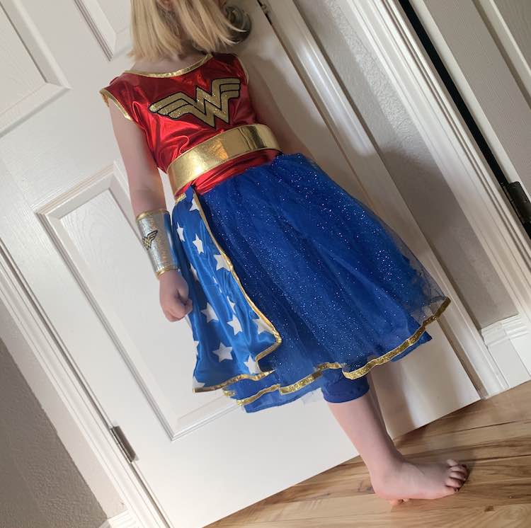 Closeup view of the front of Ada's costume with the homemade leggings poking out the bottom of the dress.