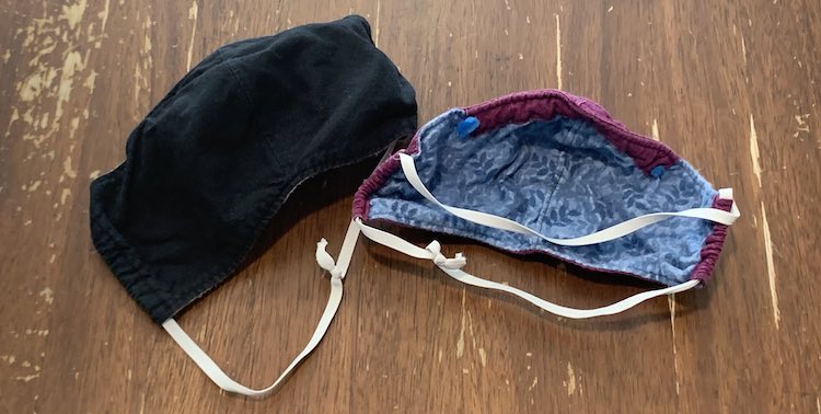 Image shows a black face mask on the left and the underside of a blue mask with purple edges and a top channel on the right. Both have white quarter inch elastic threaded through the sides and going around the back of the mask. 