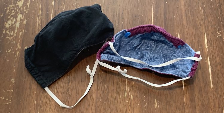 Image shows a black face mask on the left and the underside of a blue mask with purple edges and a top channel on the right. Both have white quarter inch elastic threaded through the sides and going around the back of the mask.