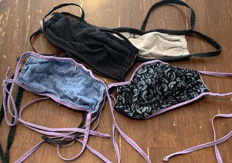 Image shows four slightly wrinkled but good condition face masks laid out on the kitchen table.