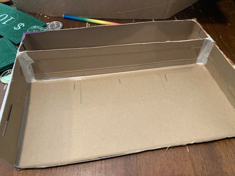 Image shows the box marked with two longer marks and three smaller marks.