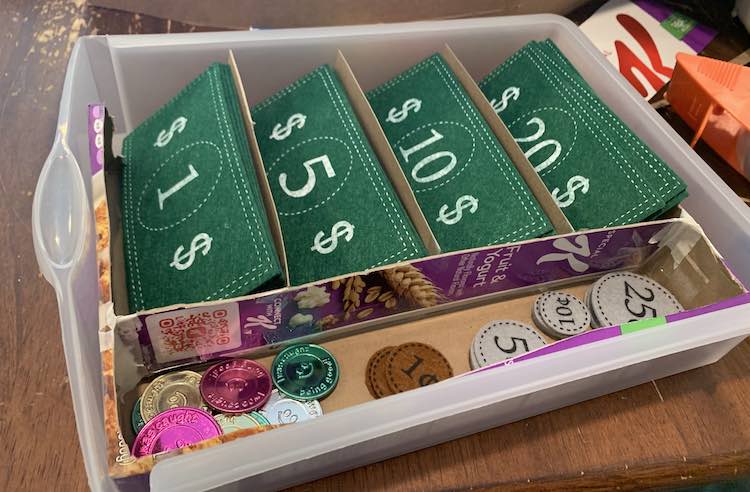 Image shows the plastic drawer sitting on the table with the coins and bills all perfectly organized within. 