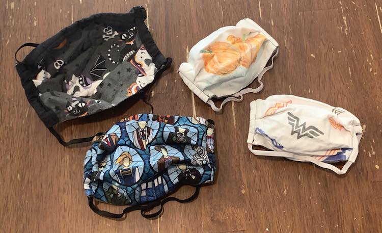 Image shows the underside of Matt's mask and the outer side of mine and the kids masks. The two adult ones, on the left, are fully opened so you can see how much bigger they are in the center with the pleats.