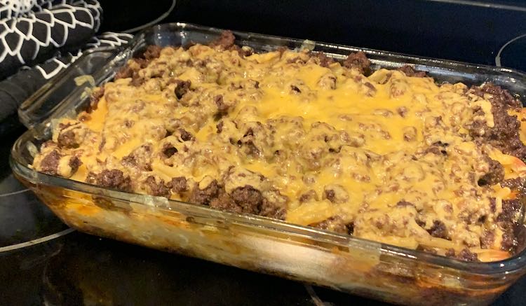 Image shows the taco lasagna-ish fresh out of the oven. It's coated in melted orange cheese. 