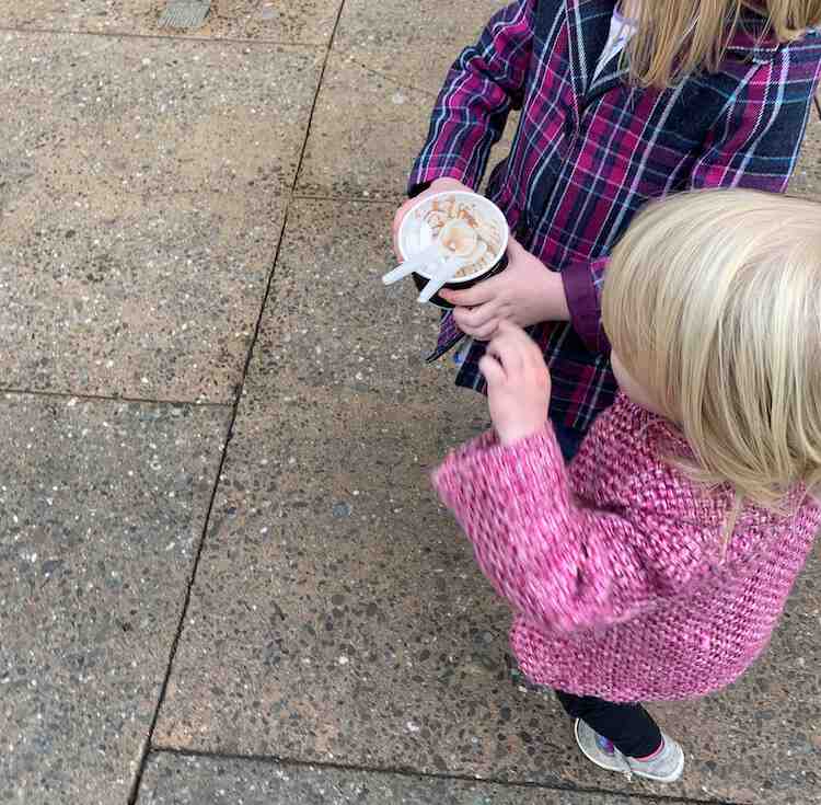 Image is take from above looking down at Ada and Zoey carrying the empty cup with spoons. 