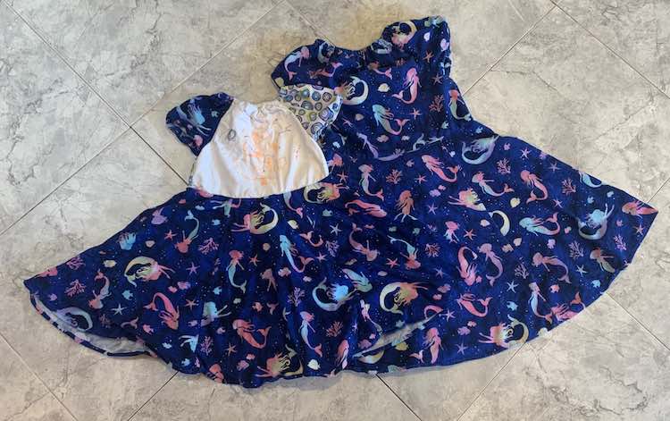 Flat lay of the two dresses on the kitchen floor. 